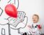 smiling toddler holding red balloon